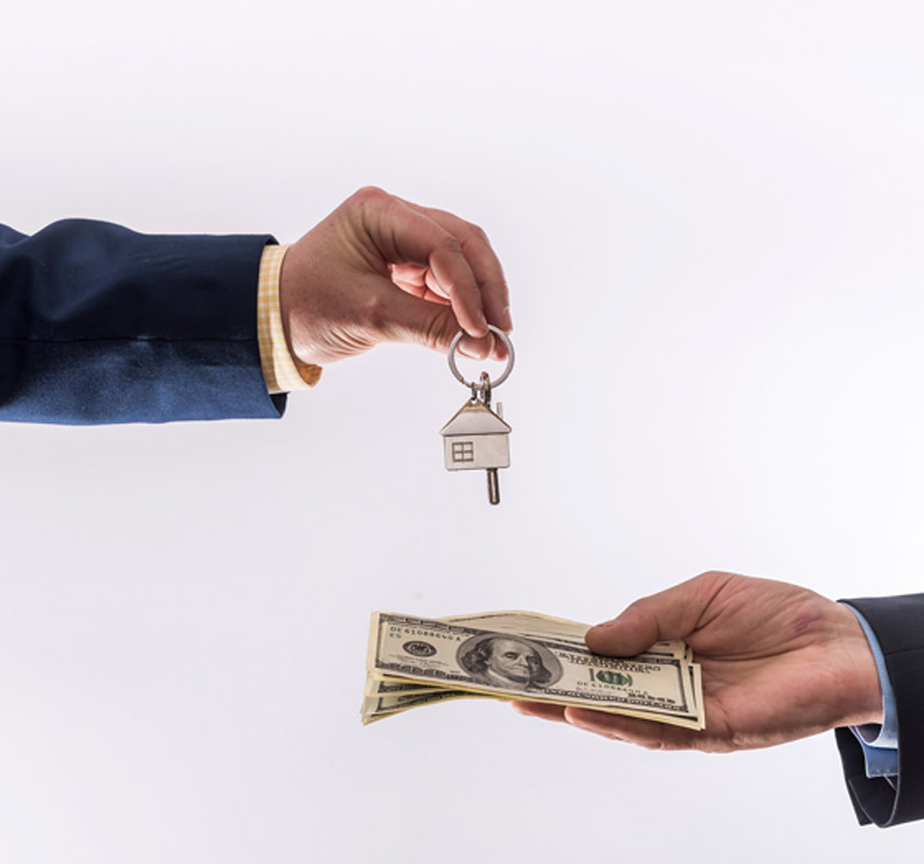 Two-hands-exchanging-cash-and-a-key-after-quickly-selling-a-house-in-Las-Vegas