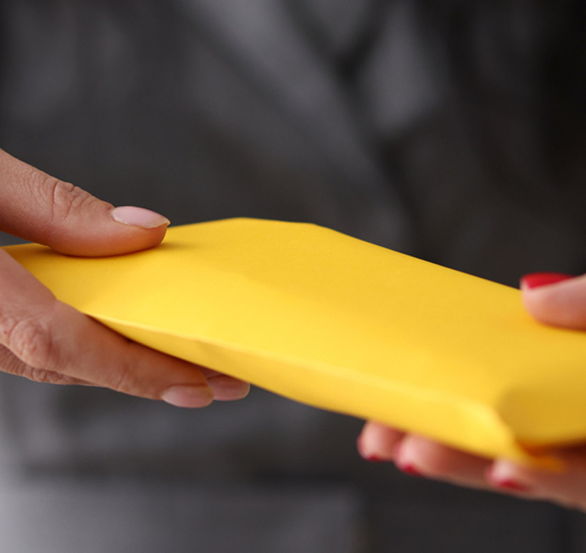Two-hands-exchanging-yellow-envelope
