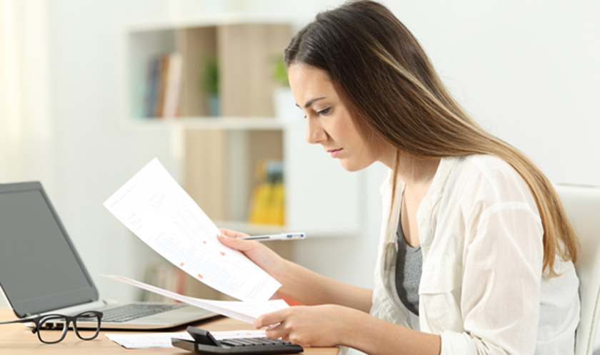 Woman-reviewing-paperwork-during-all-cash-home-purchase-process